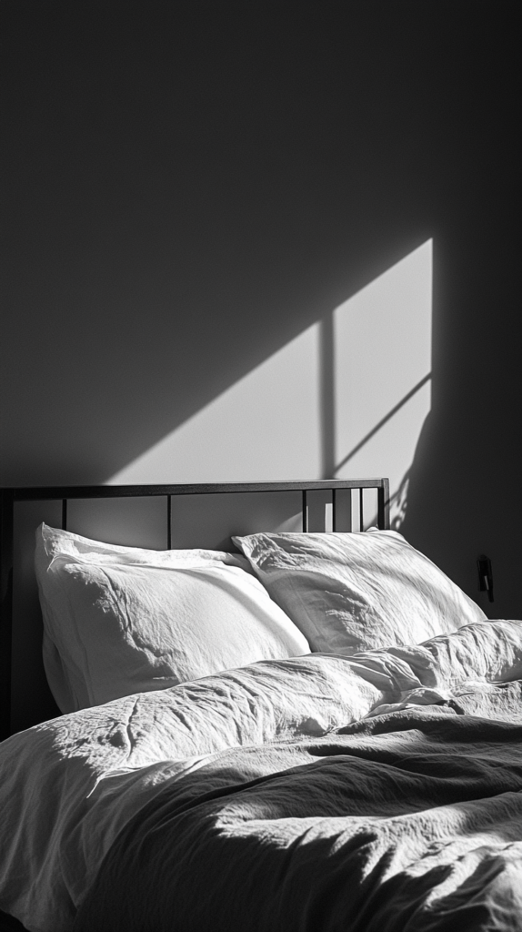 Steingraue Wand mit minimalistischer Einrichtung und schwarzem Rahmenbett